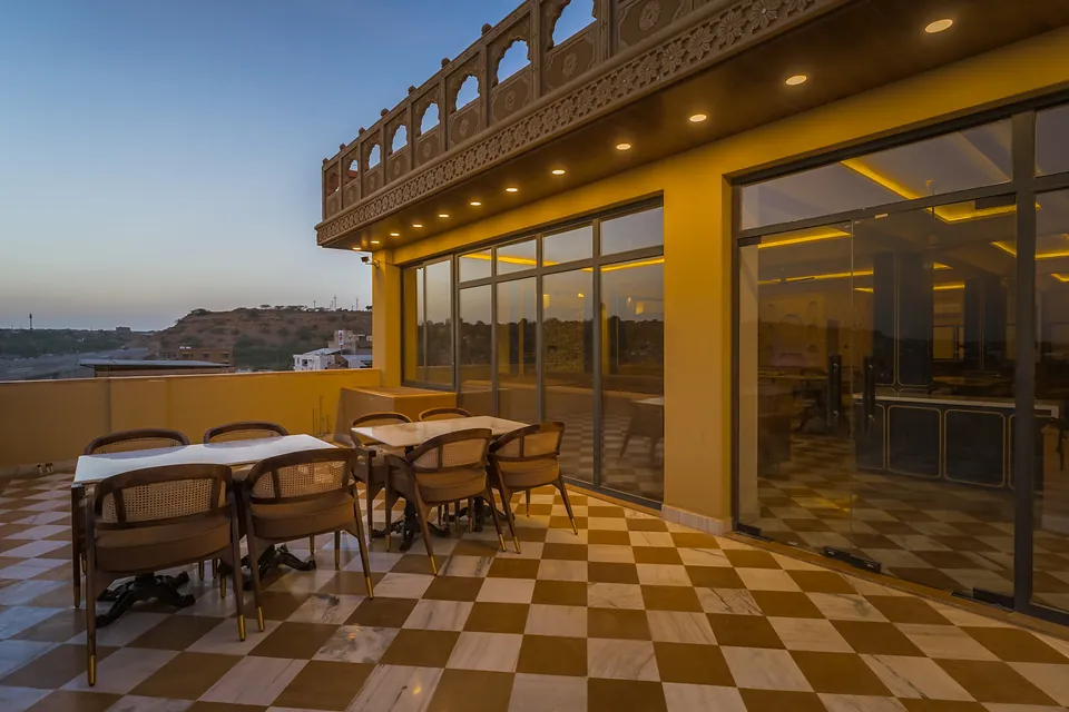 Rooftop dining terrace with checkered floor at dusk