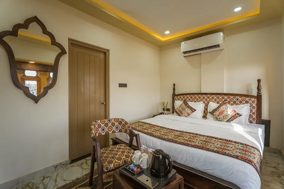 Signature Room with carved mirror, armchair and king bed